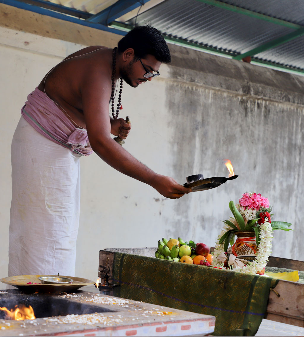 Priest performing a fire puja at an Indian temple library.