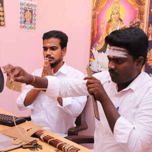 Nadi readers working with palm leaf manuscripts at a reading desk