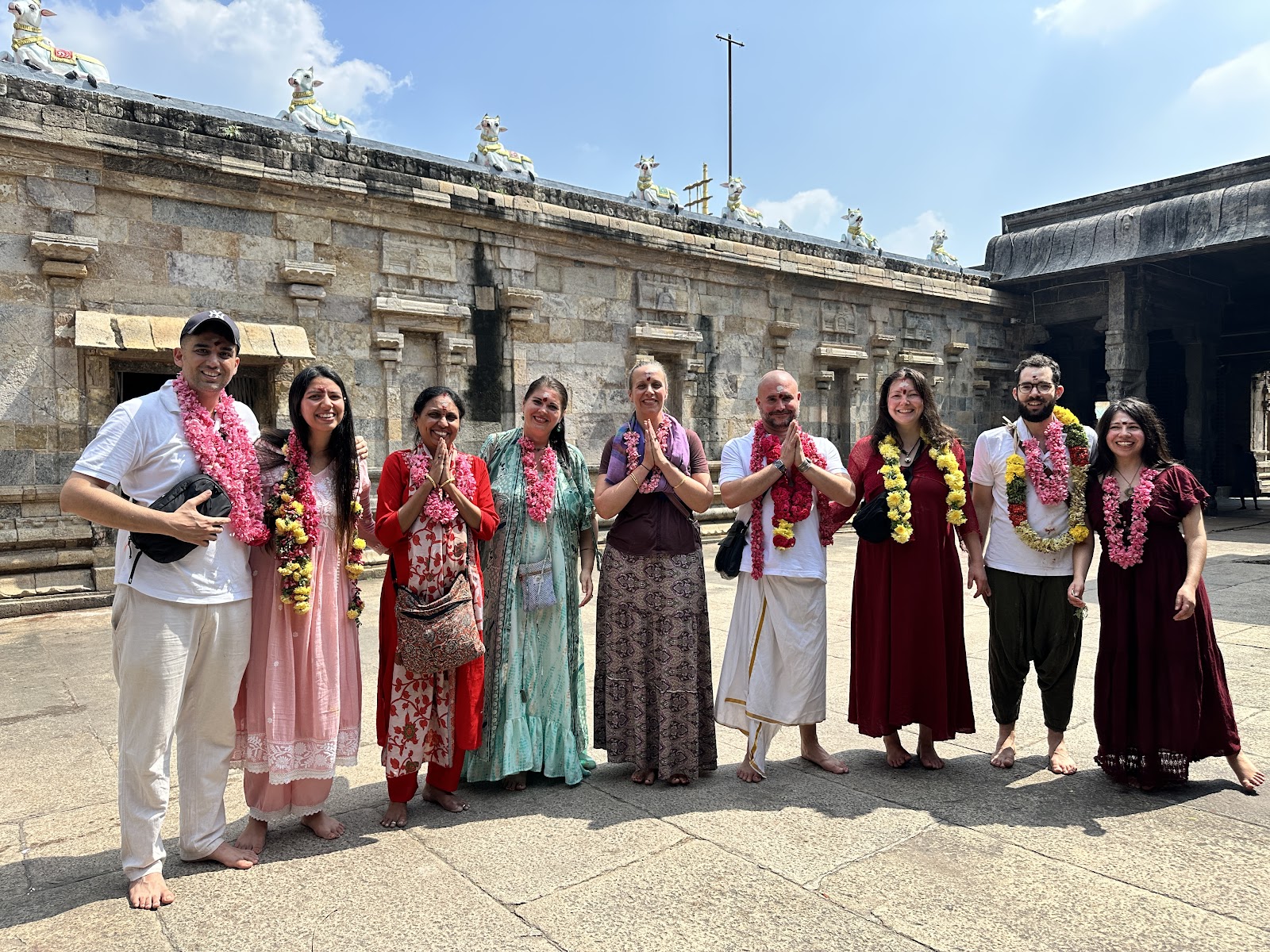 Mypalmleaf pilgrimage group with flower garlands at a South Indian temple