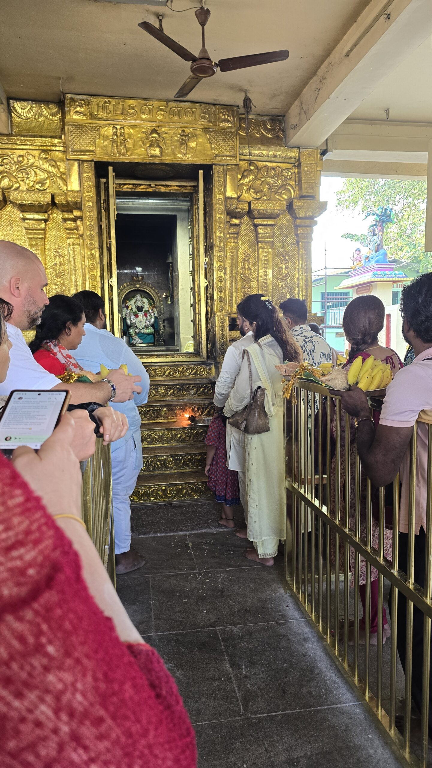 Devotees gathered before a golden temple sanctum during worship
