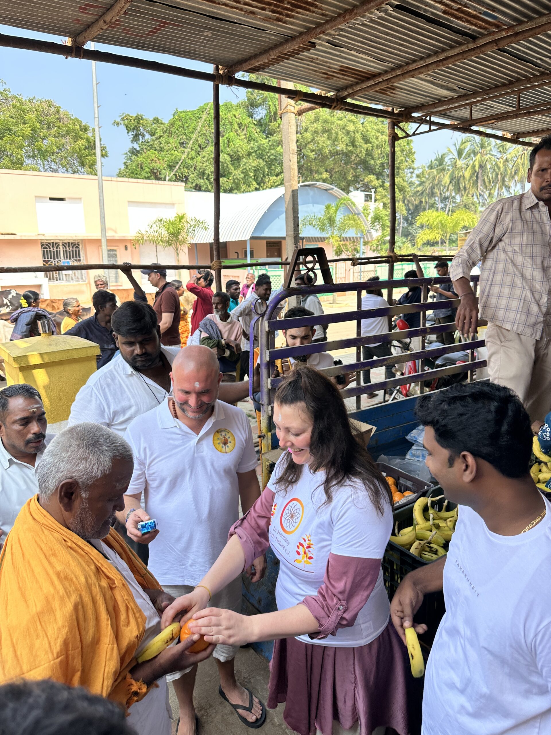 Mypalmleaf team handing fruit to an elder during a charity distribution in South India