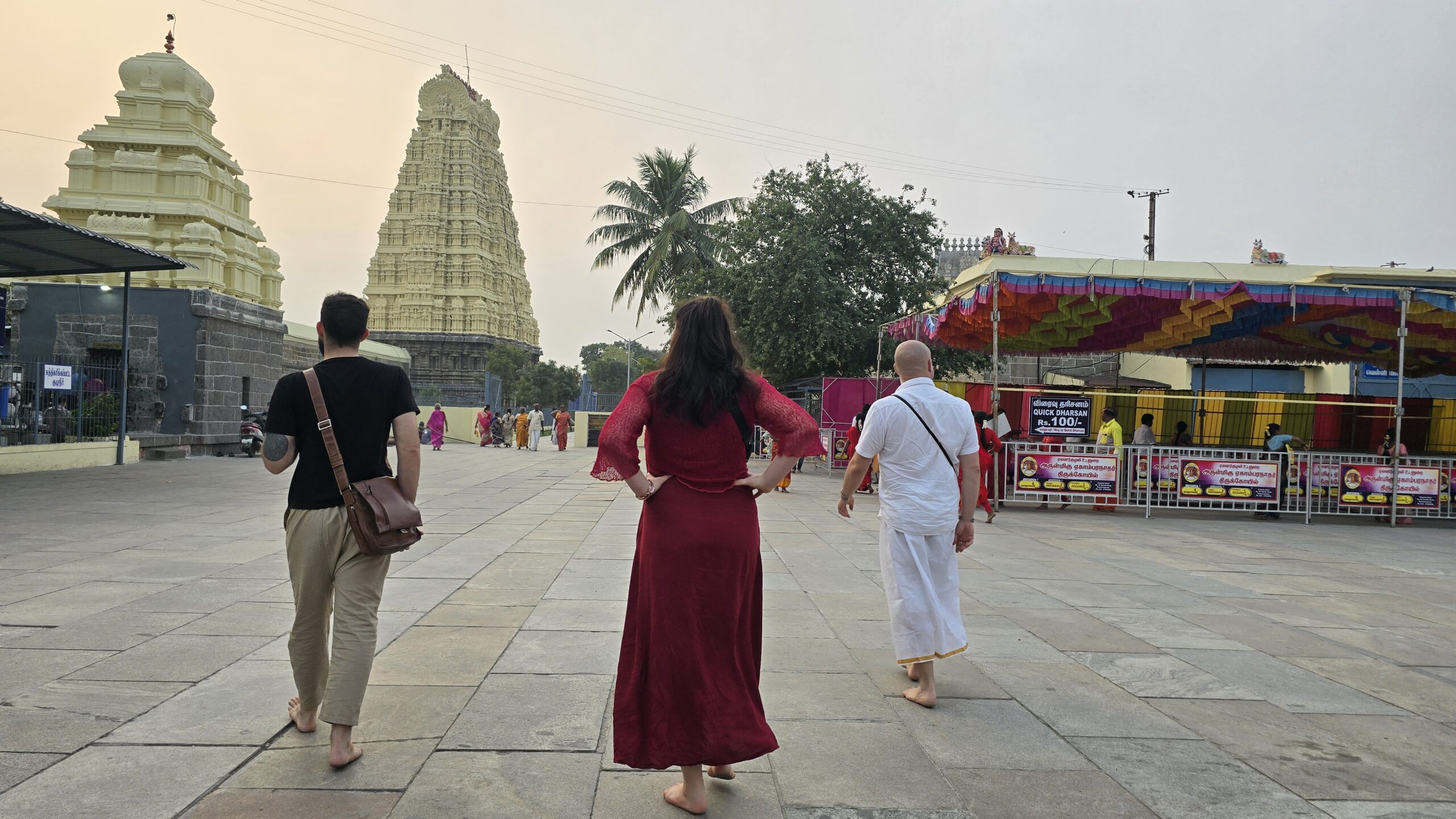 Mypalmleaf travelers walking toward the temple gopurams at dawn during a South India pilgrimage