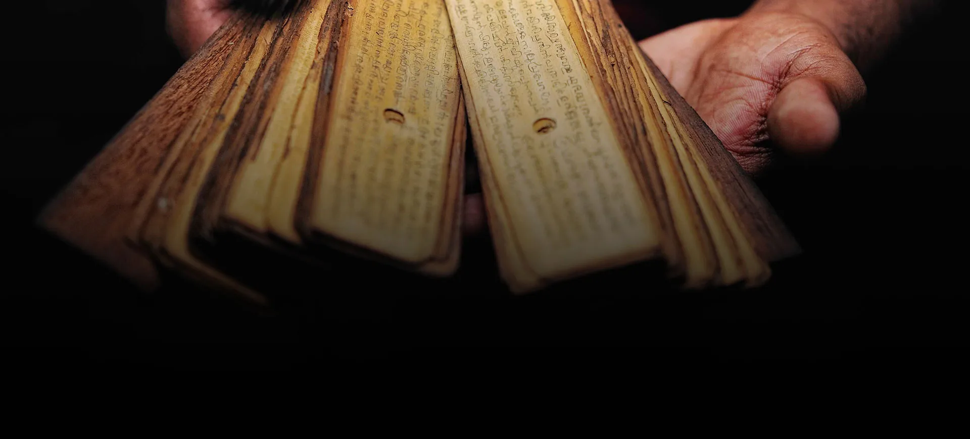 Ancient palm leaf manuscript being reviewed by a Nadi astrologer