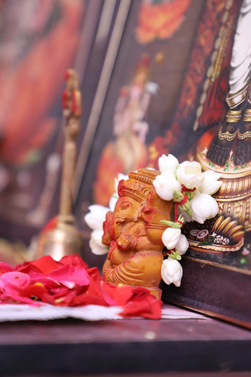 Small Ganesha idol adorned with jasmine flowers on a home altar
