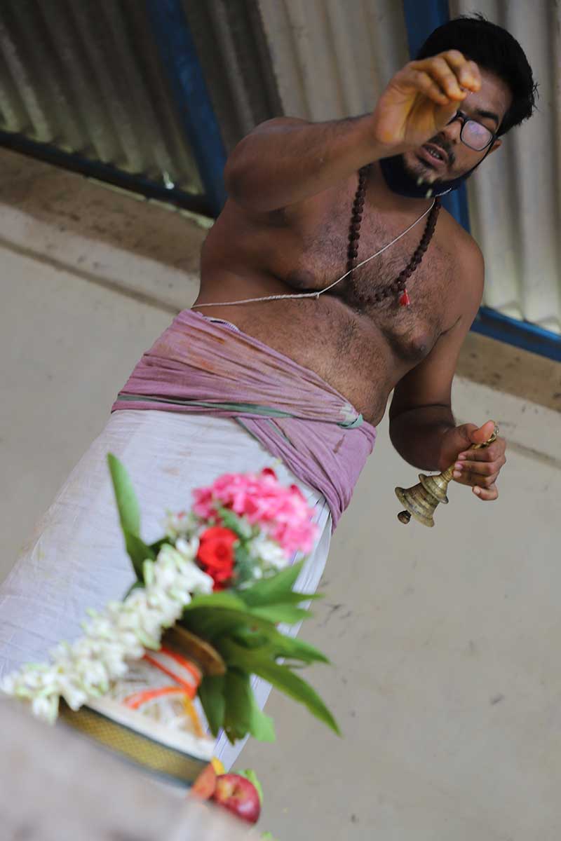 Priest ringing a ceremonial bell during a Hindu temple ritual