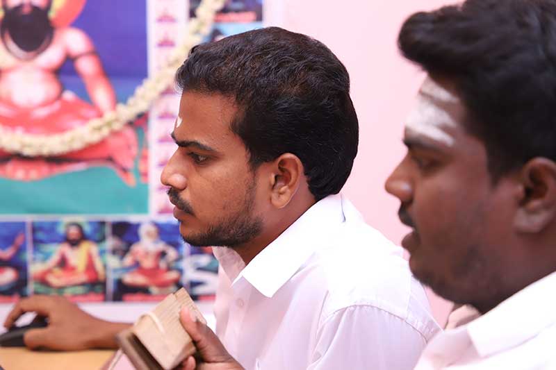 Nadi readers examining a palm leaf manuscript at a reading centre
