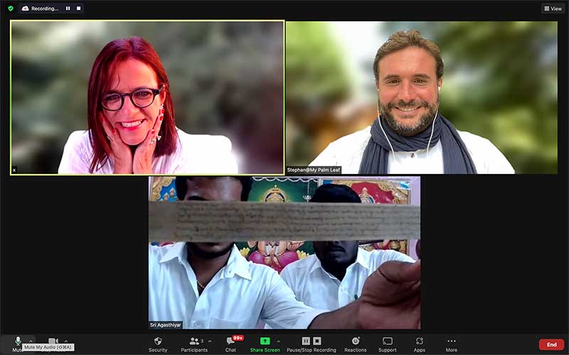 Zoom screen of an online palm leaf reading with readers holding the manuscript