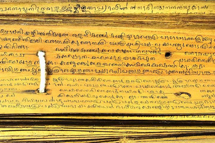 Close-up of ancient script inscribed on a palm leaf manuscript page