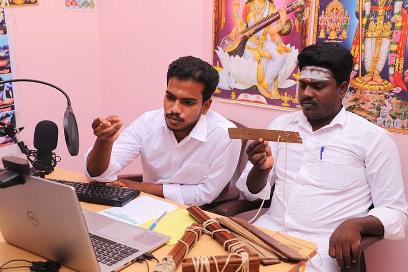 Nadi readers examining palm leaf manuscripts during an online reading