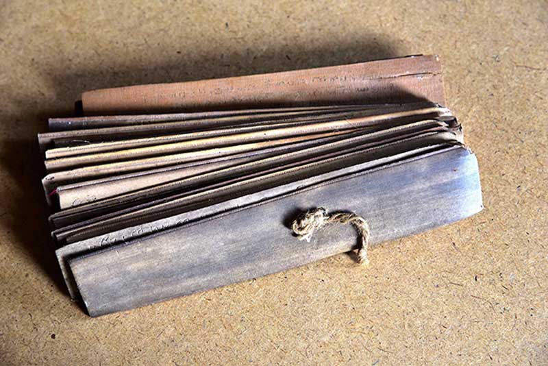 A bundle of ancient palm leaf manuscript strips tied with cord