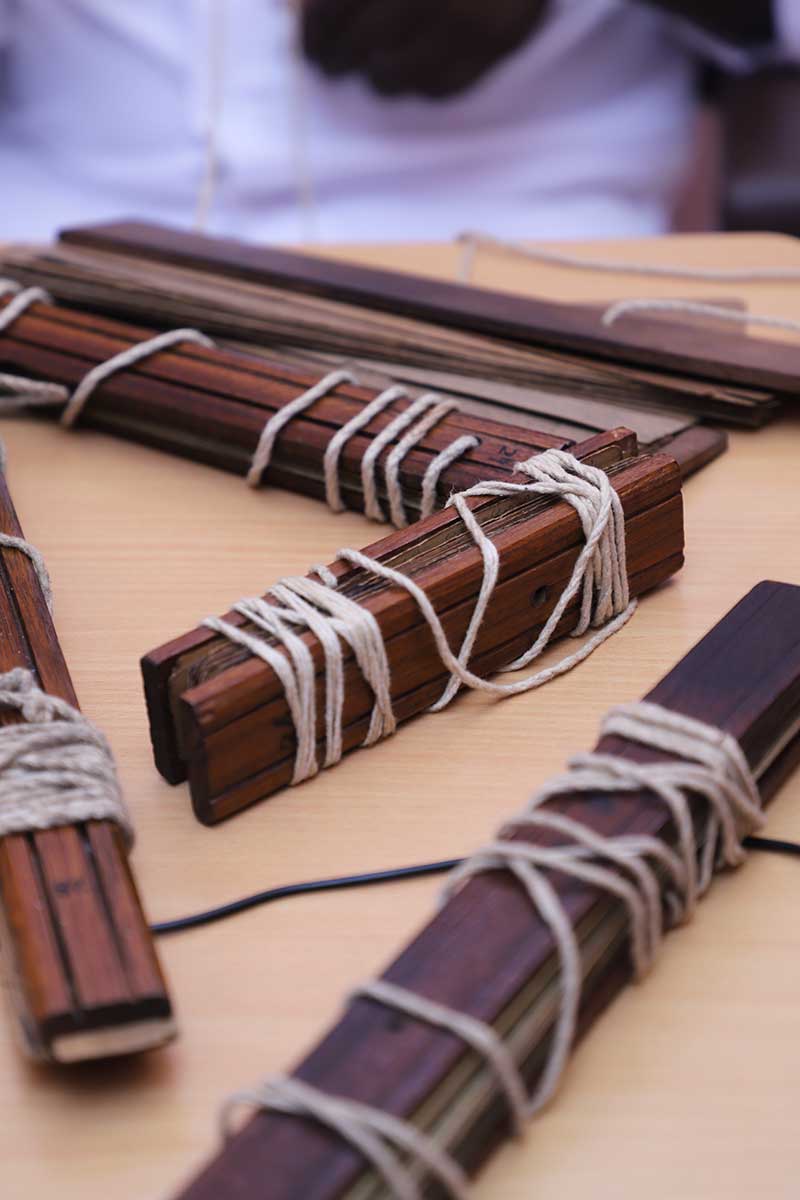 Bundles of ancient palm leaf manuscripts on a table