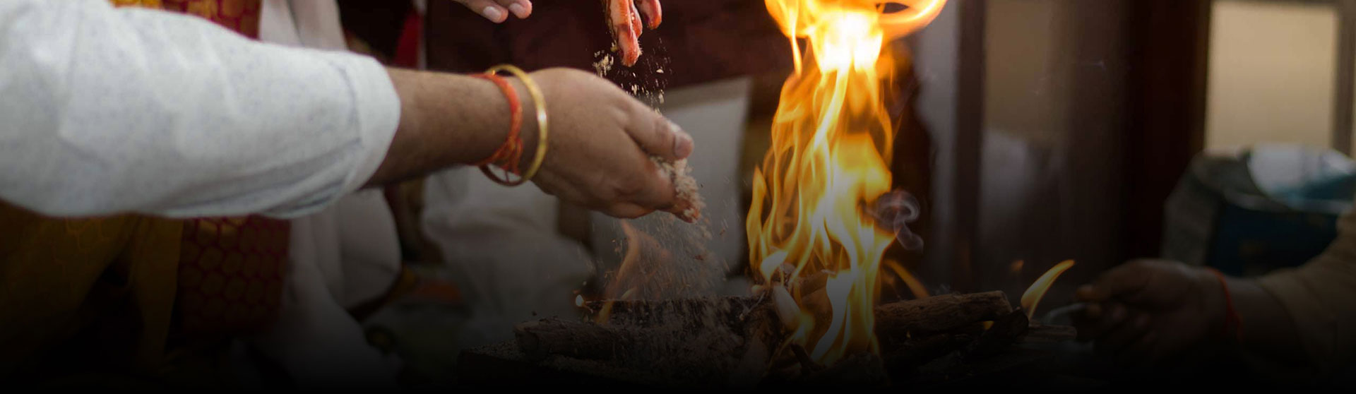 Hands offering into the sacred homa fire during a Vedic ceremony