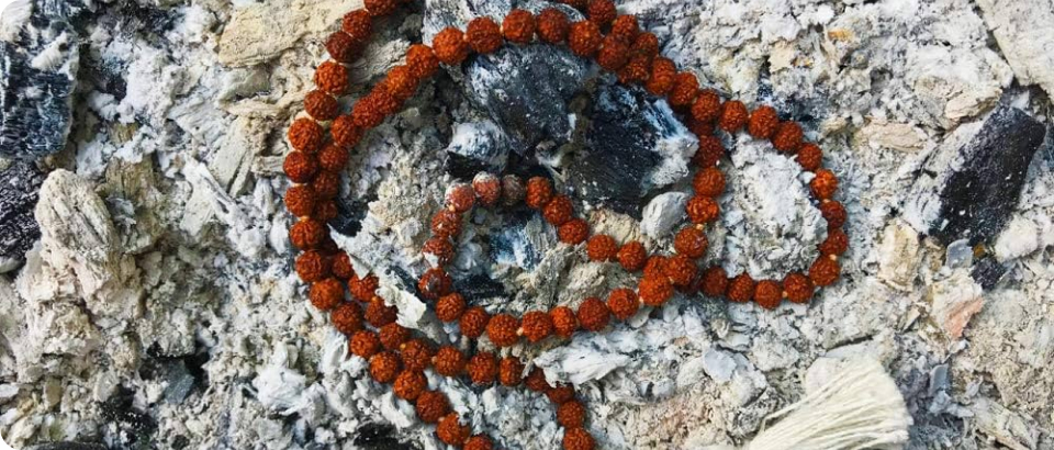 Rudraksha bead mala resting on the ashes of a sacred fire