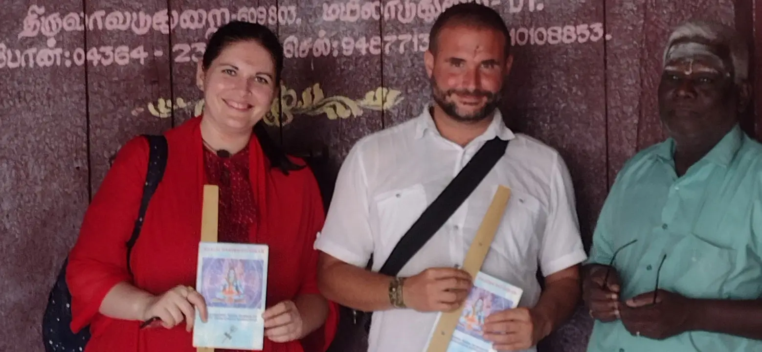 Couple holding their reading booklets outside a temple with a Nadi reader