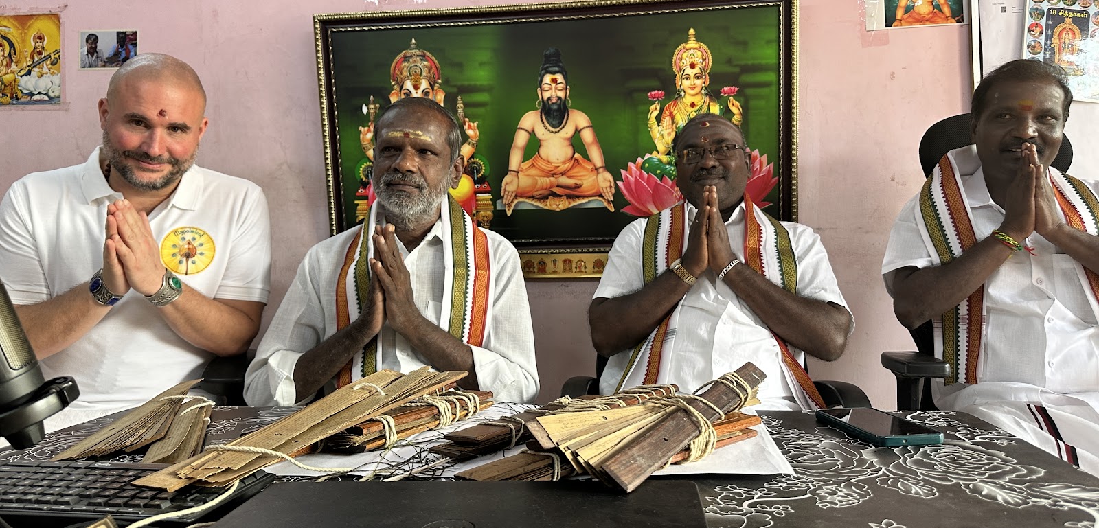 Mypalmleaf host with Nadi readers greeting with namaste at a palm leaf reading desk