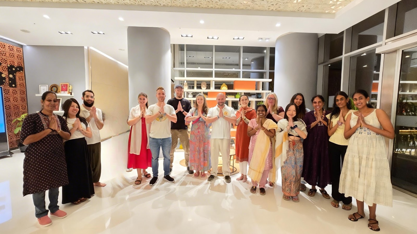 Mypalmleaf pilgrimage group greeting with namaste in a hotel lobby